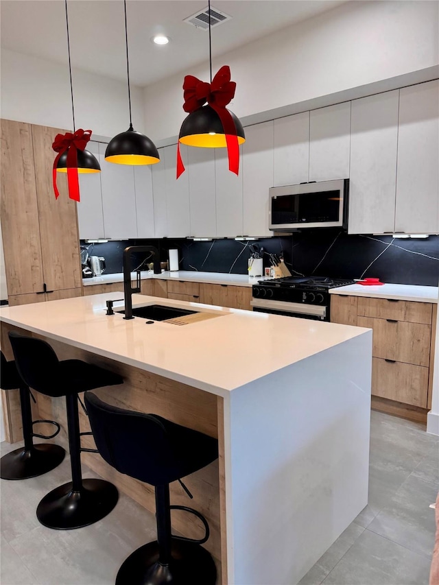 113 E 32nd St Unit A, Houston, TX 77018 - kitchen with stainless steel microwave, gas stove, modern cabinets, a sink, and white cabinets