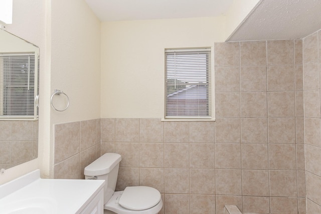 18610 Anne Dr, Webster, TX 77058 - bathroom with toilet, tile walls, vanity, and a wainscoted wall