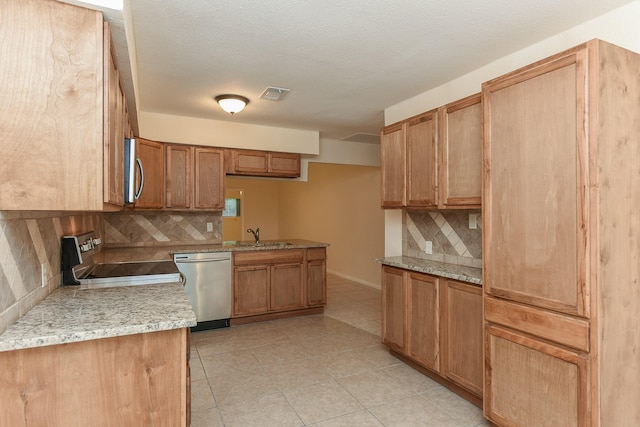 18610 Anne Dr, Webster, TX 77058 - kitchen featuring appliances with stainless steel finishes, decorative backsplash, light tile patterned floors, a sink, and light stone countertops