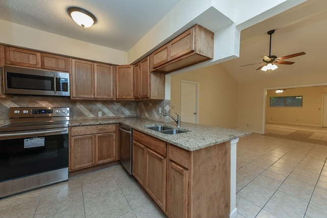 18610 Anne Dr, Webster, TX 77058 - kitchen with appliances with stainless steel finishes, a sink, tasteful backsplash, light tile patterned flooring, and vaulted ceiling