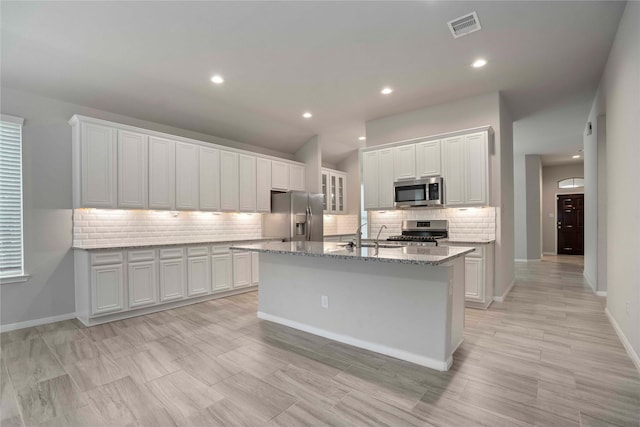 18219 Octavio Frias Trl, Houston, TX 77044 - kitchen with stainless steel appliances, backsplash, a kitchen island with sink, white cabinetry, and recessed lighting