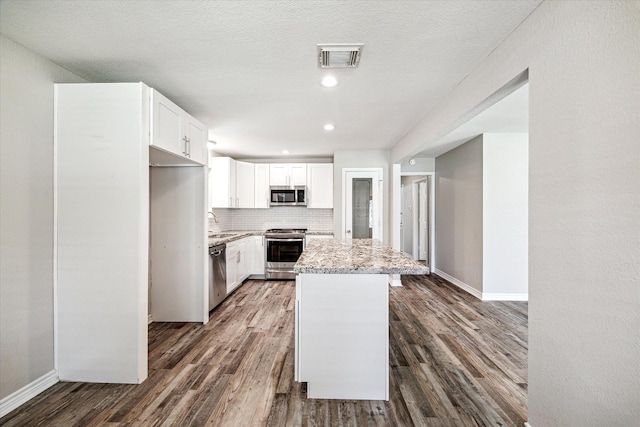 2531 Meandering Trl, Houston, TX 77339 - kitchen with stainless steel appliances, dark wood finished floors, light stone countertops, baseboards, and backsplash