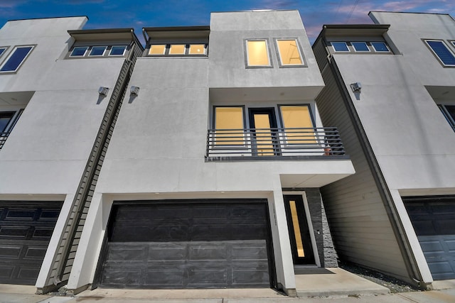1805 Blodgett St, Houston, TX 77004 - view of front facade featuring stucco siding, a balcony, and a garage