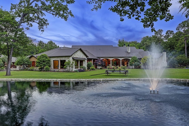 10002 Oxted Ln, Spring, TX 77379 - rear view of property featuring a water view, a lawn, metal roof, a standing seam roof, and driveway