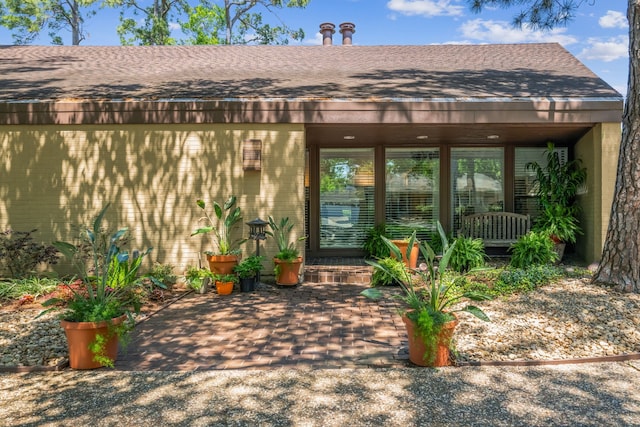 10318 Pine Forest Rd, Houston, TX 77042 - doorway to property with roof with shingles and brick siding