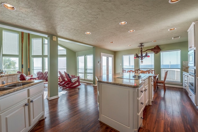 131 Isles End Rd, Tiki Island, TX 77554 - kitchen featuring a sink, stainless steel appliances, white cabinets, a textured ceiling, and dark wood finished floors