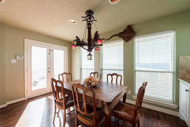 131 Isles End Rd, Tiki Island, TX 77554 - dining room featuring healthy amount of natural light, baseboards, dark wood finished floors, and a textured ceiling