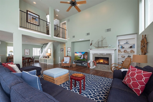 131 Isles End Rd, Tiki Island, TX 77554 - living area with ceiling fan, wood finished floors, a high ceiling, a fireplace, and stairway