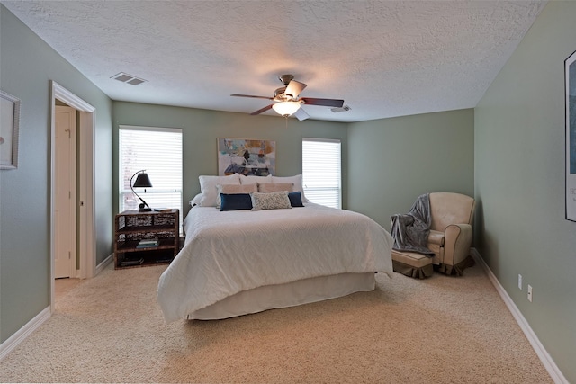 131 Isles End Rd, Tiki Island, TX 77554 - bedroom with light colored carpet, a textured ceiling, baseboards, and a ceiling fan