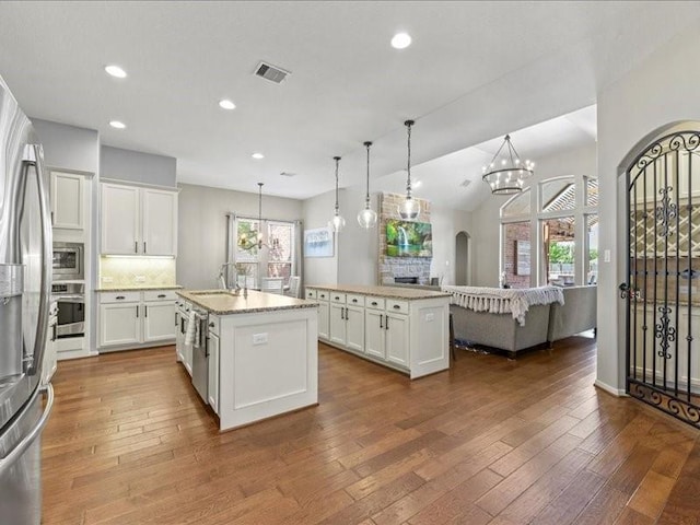 17806 Creek Bluff Ln, Cypress, TX 77433 - kitchen with appliances with stainless steel finishes, a center island with sink, a sink, dark wood-style flooring, and recessed lighting