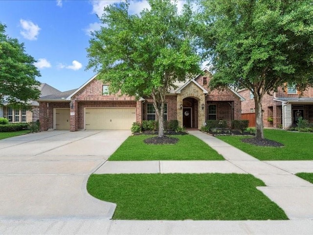 17806 Creek Bluff Ln, Cypress, TX 77433 - view of front of home with a front lawn, an attached garage, driveway, and brick siding