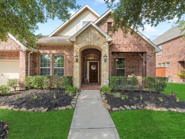 17806 Creek Bluff Ln, Cypress, TX 77433 - tudor house with stone siding, brick siding, a garage, and a front lawn