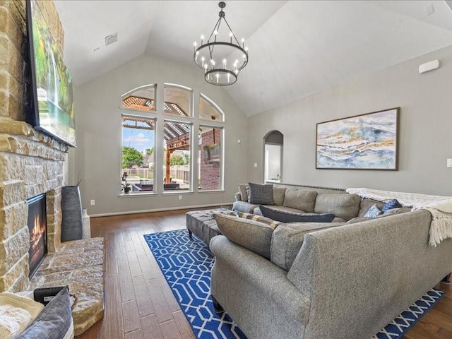 17806 Creek Bluff Ln, Cypress, TX 77433 - living area featuring arched walkways, wood-type flooring, a fireplace, a chandelier, and high vaulted ceiling