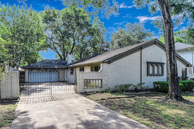 6902 Wagonwheel Ln, Houston, TX 77088 - view of front of house with driveway, a gate, brick siding, a chimney, and a garage