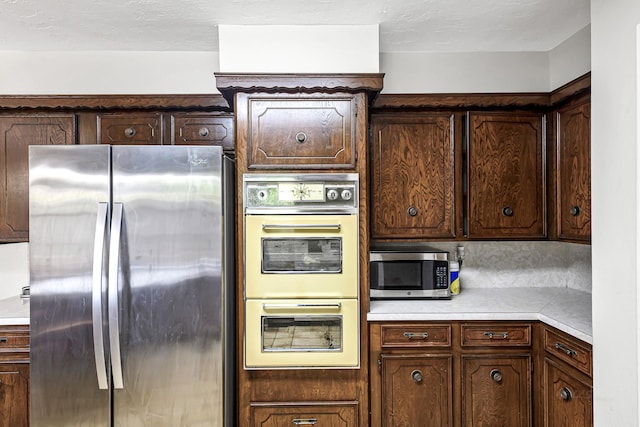 6902 Wagonwheel Ln, Houston, TX 77088 - kitchen with appliances with stainless steel finishes, light countertops, and dark brown cabinets