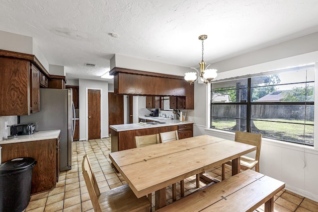 6902 Wagonwheel Ln, Houston, TX 77088 - dining space featuring a chandelier, light tile patterned flooring, and a textured ceiling