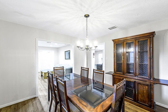 6902 Wagonwheel Ln, Houston, TX 77088 - dining area featuring a chandelier, wood finished floors, and baseboards