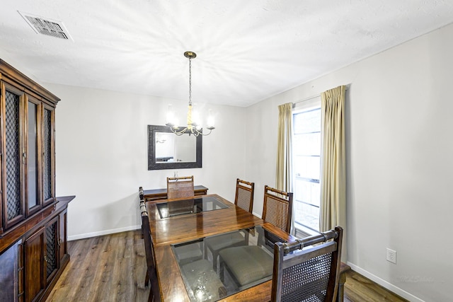 6902 Wagonwheel Ln, Houston, TX 77088 - dining space with a chandelier, dark wood finished floors, and baseboards