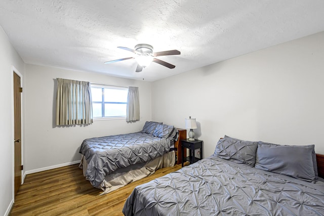 6902 Wagonwheel Ln, Houston, TX 77088 - bedroom featuring wood finished floors, a textured ceiling, baseboards, and ceiling fan