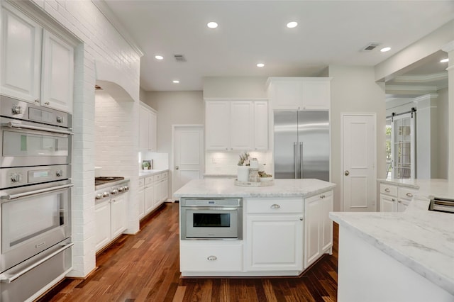 3350 Precinct Line Rd, Richmond, TX 77406 - kitchen with stainless steel appliances, a warming drawer, tasteful backsplash, dark wood-style floors, and a center island