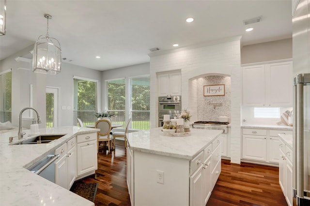 3350 Precinct Line Rd, Richmond, TX 77406 - kitchen featuring a sink, appliances with stainless steel finishes, dark wood-style flooring, a center island, and white cabinetry
