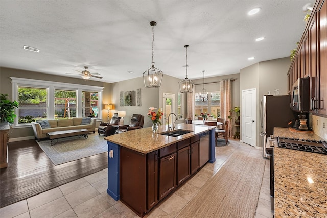 14327 Cranbrook Creek Ln, Houston, TX 77044 - kitchen with a sink, stainless steel appliances, a center island with sink, healthy amount of natural light, and a textured ceiling