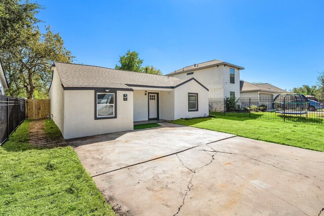 7109 Saint Augustine St, Houston, TX 77021 - view of front of house with stucco siding, a trampoline, a patio, and a shingled roof