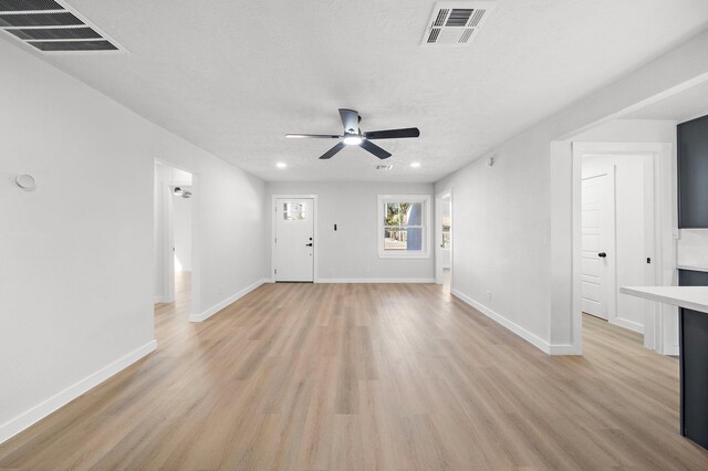 7109 Saint Augustine St, Houston, TX 77021 - unfurnished living room featuring light wood finished floors, ceiling fan, baseboards, recessed lighting, and a textured ceiling