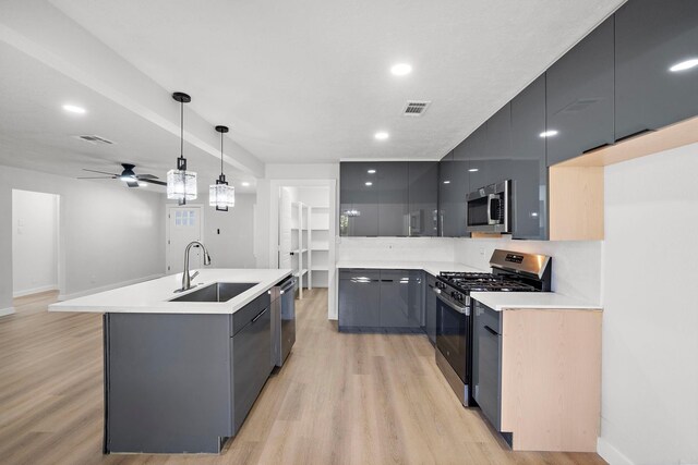 7109 Saint Augustine St, Houston, TX 77021 - kitchen featuring stainless steel appliances, a sink, modern cabinets, light wood-style floors, and recessed lighting