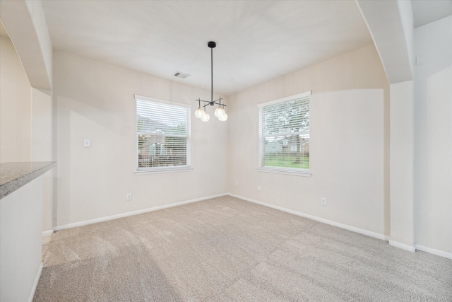 18621 Serenity Loch Dr, Spring, TX 77379 - empty room featuring plenty of natural light, carpet, a chandelier, and baseboards