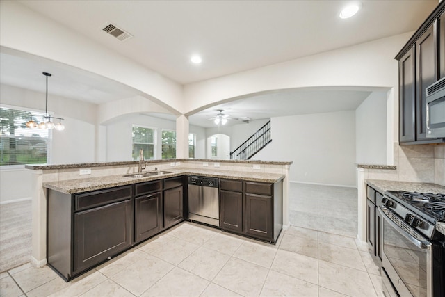 18621 Serenity Loch Dr, Spring, TX 77379 - kitchen featuring appliances with stainless steel finishes, a sink, arched walkways, light carpet, and recessed lighting