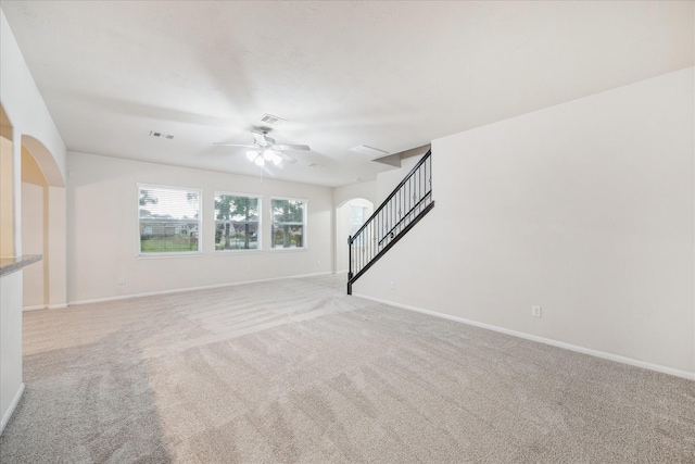 18621 Serenity Loch Dr, Spring, TX 77379 - unfurnished living room with stairway, carpet floors, ceiling fan, and baseboards