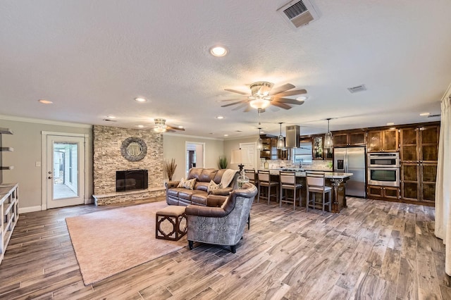 29742 Geneva Dr, Spring, TX 77386 - living area with ceiling fan, a fireplace, crown molding, plenty of natural light, and recessed lighting