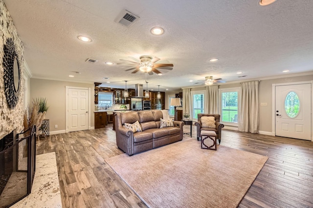 29742 Geneva Dr, Spring, TX 77386 - living room featuring crown molding, a textured ceiling, a ceiling fan, hardwood / wood-style floors, and recessed lighting