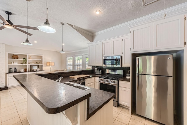 29742 Geneva Dr, Spring, TX 77386 - kitchen with appliances with stainless steel finishes, a sink, dark countertops, light tile patterned floors, and crown molding