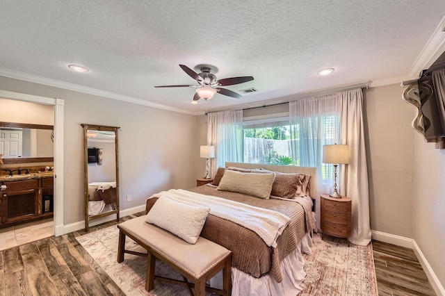 29742 Geneva Dr, Spring, TX 77386 - bedroom with wood finished floors, a textured ceiling, ornamental molding, baseboards, and a sink