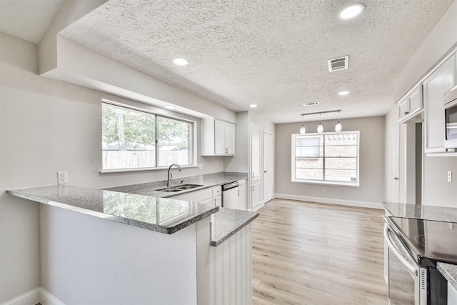23203 Pennsgrove Rd, Spring, TX 77373 - kitchen with a sink, appliances with stainless steel finishes, light stone counters, a textured ceiling, and white cabinetry