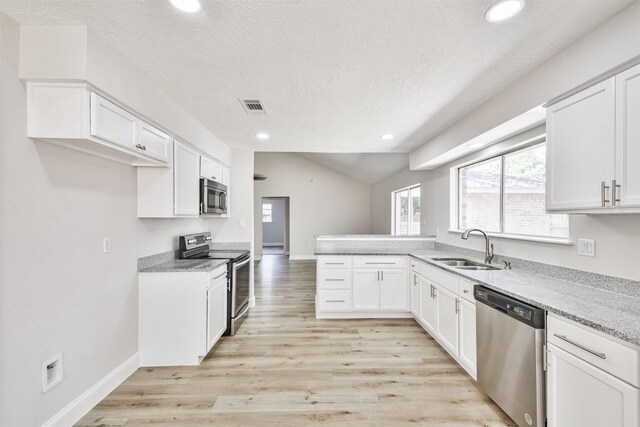 23203 Pennsgrove Rd, Spring, TX 77373 - kitchen with stainless steel appliances, a sink, a textured ceiling, recessed lighting, and white cabinets