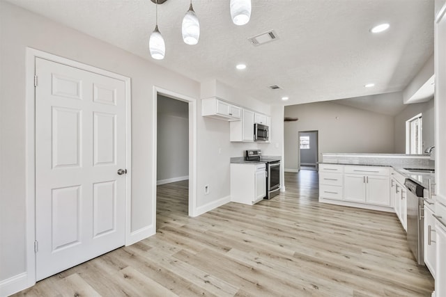 23203 Pennsgrove Rd, Spring, TX 77373 - kitchen with appliances with stainless steel finishes, a sink, a peninsula, white cabinets, and light wood finished floors