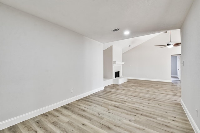 23203 Pennsgrove Rd, Spring, TX 77373 - unfurnished living room featuring light wood finished floors, lofted ceiling, baseboards, ceiling fan, and a fireplace with raised hearth
