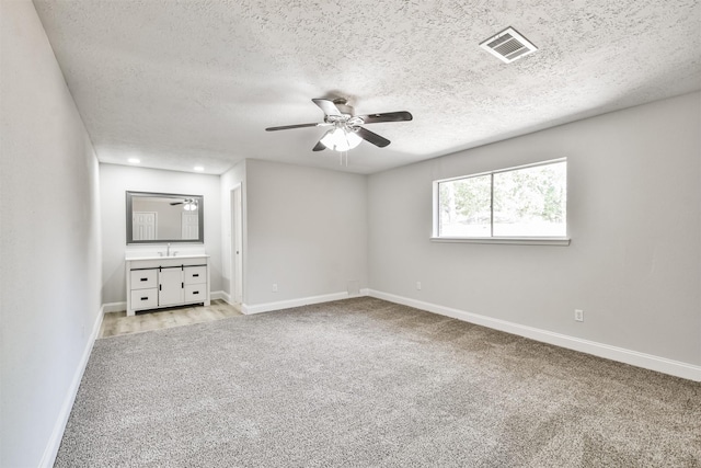 23203 Pennsgrove Rd, Spring, TX 77373 - unfurnished bedroom with light carpet, baseboards, a textured ceiling, a sink, and ceiling fan