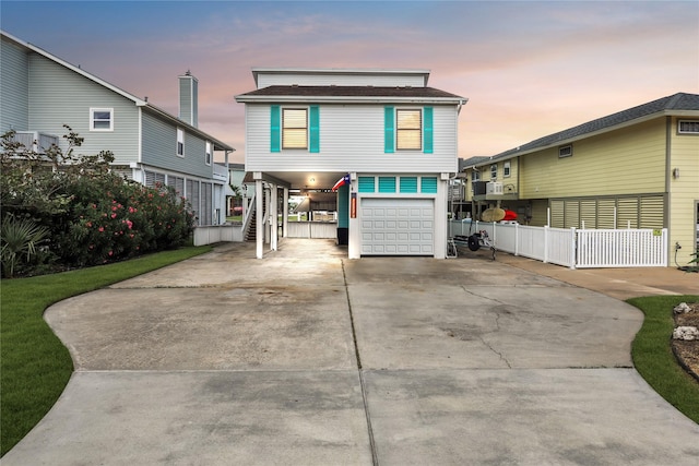 1114 Tiki Dr, Galveston, TX 77554 - coastal inspired home with driveway, a carport, and an attached garage
