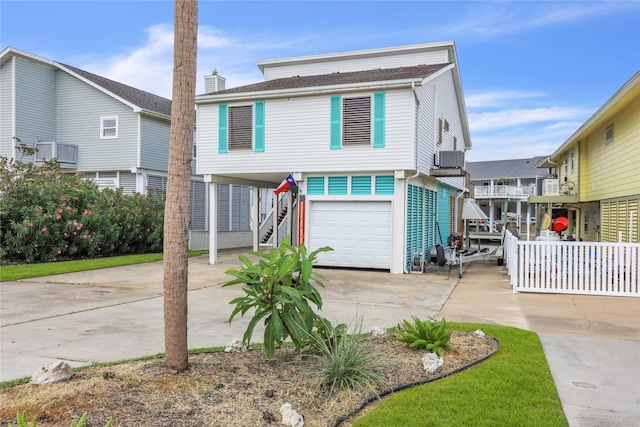 1114 Tiki Dr, Galveston, TX 77554 - coastal inspired home with a carport, stairway, concrete driveway, an attached garage, and a chimney