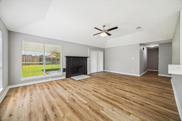 16739 Sky Blue Ln, Houston, TX 77095 - unfurnished living room featuring lofted ceiling, wood finished floors, baseboards, a ceiling fan, and a tile fireplace