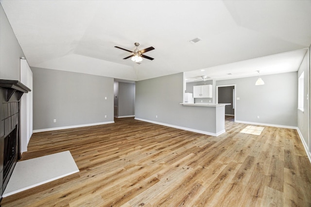 16739 Sky Blue Ln, Houston, TX 77095 - unfurnished living room featuring a ceiling fan, vaulted ceiling, light wood-style flooring, a fireplace, and baseboards