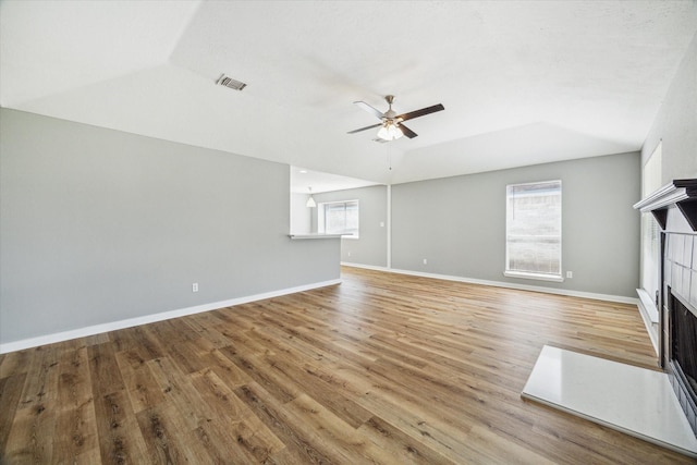 16739 Sky Blue Ln, Houston, TX 77095 - unfurnished living room with a fireplace, a ceiling fan, wood finished floors, vaulted ceiling, and baseboards