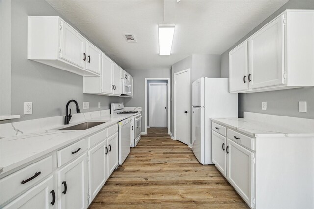 16739 Sky Blue Ln, Houston, TX 77095 - kitchen with a sink, white appliances, light wood-type flooring, and white cabinets