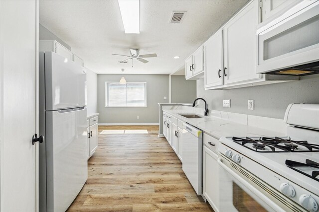 16739 Sky Blue Ln, Houston, TX 77095 - kitchen with white appliances, a sink, white cabinetry, ceiling fan, and light wood-type flooring