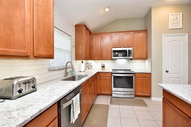 711 Shenandoah Falls Ln, Rosenberg, TX 77469 - kitchen with stainless steel appliances, a sink, decorative backsplash, lofted ceiling, and light stone countertops
