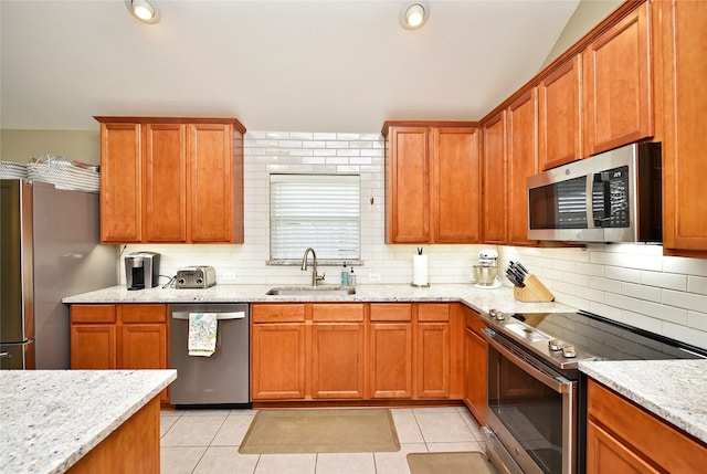 711 Shenandoah Falls Ln, Rosenberg, TX 77469 - kitchen with stainless steel appliances, a sink, tasteful backsplash, and light tile patterned flooring